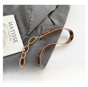 Close-up of leopard print shoulder strap with brown acrylic chain links and gold hardware