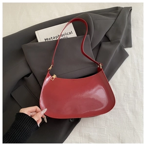 Dettaglio borsa hobo in pelle verniciata bordeaux con cerniera dorata e forma a luna