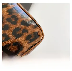Close-up of glossy leopard print leather material with brown stitched edge detailing