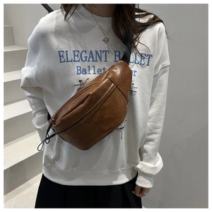 Brown vintage PU leather crescent chest bag shown worn by model with adjustable strap