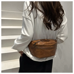 Detailed back view of vintage brown leather waist bag featuring textured dual zipper pockets