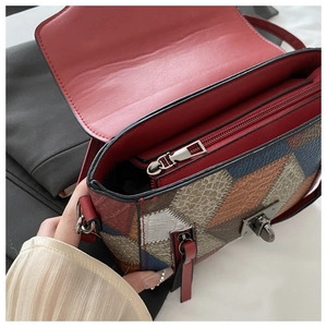 Detail of color-block square bag showing the metal twist lock and interior zip pocket