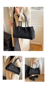 Macro detail of large black faux suede tote bag with durable stitching and leather handles