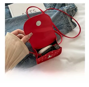 Vue intérieure du mini sac rouge à pois avec espace pour rouge à lèvres et poudre