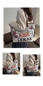 Detail of white graffiti tote bag featuring cartoon bear motifs and brown leather handles