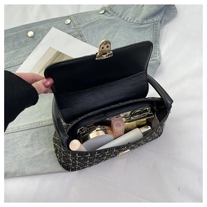 Vista interna di una borsa a quadri in tweed nero con fibbia in metallo dorato e spazio