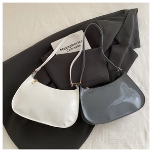 Borse hobo minimaliste in pelle verniciata lucida bianca e grigia su un blazer