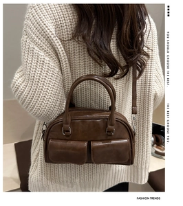 Brown vintage Boston bag with double front pockets and adjustable crossbody strap detail