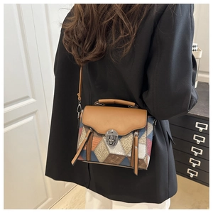 Detail of multi-color leather crossbody bag with metal turn-lock and geometric patchwork
