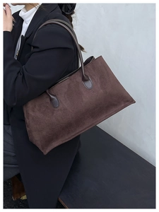 Detail of dark brown corduroy tote bag showing striped texture and leather handles