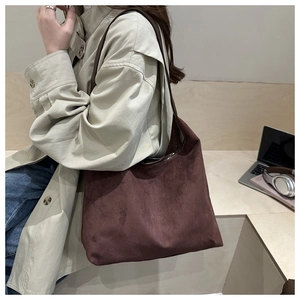 Minimalist dark brown suede tote bag styled with books and laptop for urban chic look