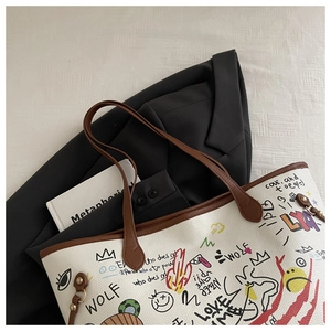 Detail of white graffiti tote bag with colorful hand-drawn text on black suit