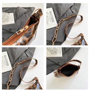 Detailed close-up of leopard print baguette bag featuring metal zipper and chain strap