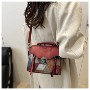 Detail of colorful geometric patchwork bag with vintage metal lock and red leather flap