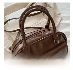 Close-up of brown faux leather texture and double front pockets on the bowling bag