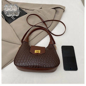 Détail du sac à main marron foncé à texture tissée avec fermoir doré et bandoulière