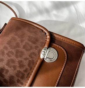 Gros plan d'un sac à main en daim et cuir marron avec une boucle en métal argenté