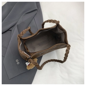 Detailed interior of vintage tote bag with grey lining and woven handle details