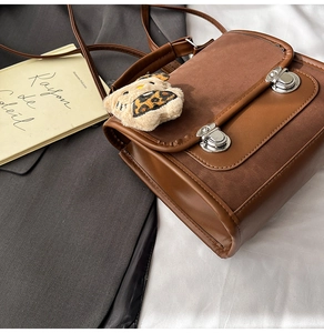 Gros plan d'un sac rétro en cuir marron avec boucles en métal et breloque léopard