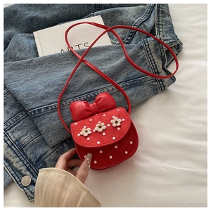 Détail du mini sac bandoulière rouge à pois avec fleurs au crochet et un nœud