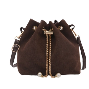 Dark brown suede bucket bag featuring gold drawstring chains and pearl decorations