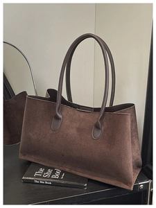 Detailed texture of dark brown suede tote bag with slim handles and spacious design