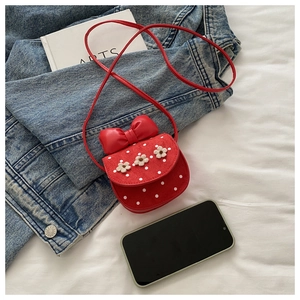 Détail du mini sac rouge à pois blancs avec fleurs 3D et grand nœud décoratif élégant
