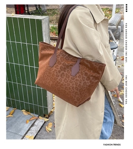 Street style view of a large leopard print tote bag with purple handles for women
