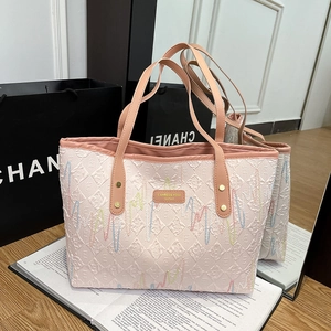 Pink quilted tote bag with colorful embroidery and brown handles for daily use