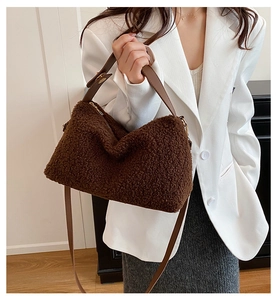 Borsa a tracolla in peluche marrone su una modella con blazer bianco e gonna