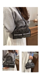Detailed views of gray leather Boston bag with front pockets and silver hardware