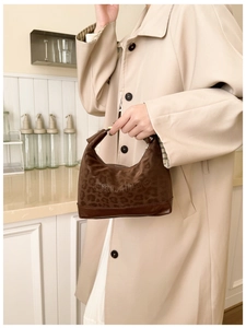 Detail of hobo shoulder bag with leopard print texture and brown faux leather base