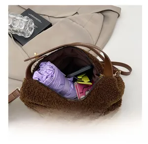 Grande capacità interna della borsa tote in peluche marrone con oggetti quotidiani