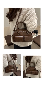 Detail view of vintage dark brown bowling bag with double pockets and crossbody strap