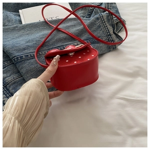 Détail du mini sac bandoulière à pois rouges et blancs avec fermoir argenté et sangle