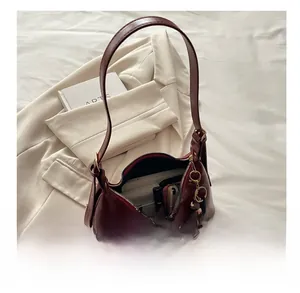 Spacious interior of dark red leather hobo bag holding a phone, wallet, and lipstick