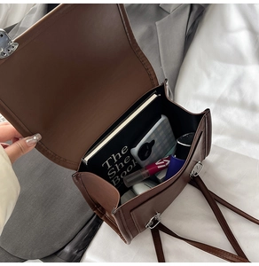 Vue intérieure d'un sac en cuir marron montrant le rangement et les accessoires