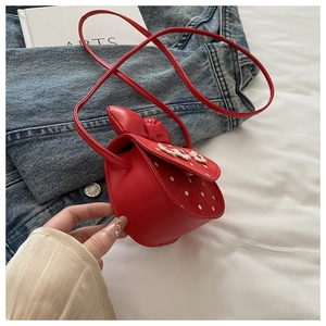Détail du sac bandoulière rouge à pois blancs avec un nœud 3D sur cuir mat