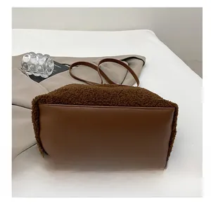 Dettaglio del fondo in finta pelle resistente di una borsa tote in peluche marrone