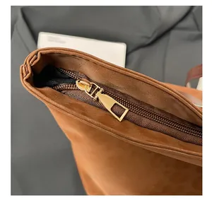 Close-up of the smooth golden zipper closure on a brown textured leopard tote bag