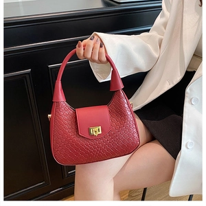 Détail du sac à main rouge tissé avec un fermoir rectangulaire en métal doré