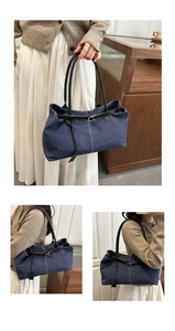 Detailed view of dark blue denim tote bag with black leather straps and metal buckle accents