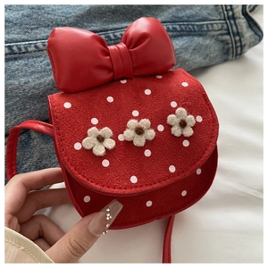 Détails d'un mini sac bandoulière vintage rouge avec des pois blancs et des fleurs