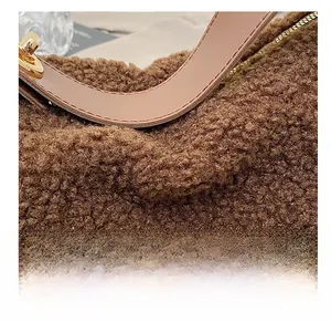 Dettaglio della texture in peluche marrone e tracolla in pelle con fibbie dorate
