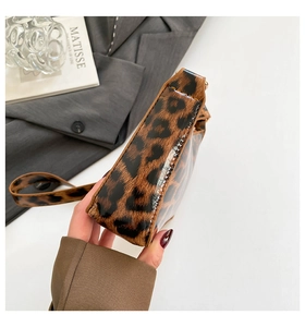 Detail view showing the sleek leopard print texture and structured side profile of the bag