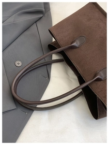 Detail view of deep brown frosted leather tote bag with long handles for shoulder wear
