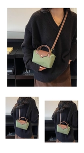 Detail of green nylon mini bag with brown leather trim and gold snap button closure