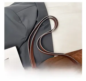 Detail of comfortable brown leather shoulder straps on a leopard print faux suede tote bag