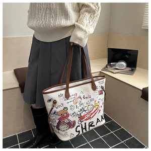 Detail of white graffiti tote bag with patch bear print and brown leather handles