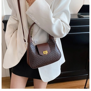 Détail du sac à bandoulière tressé marron foncé avec boucle dorée et bandoulière réglable